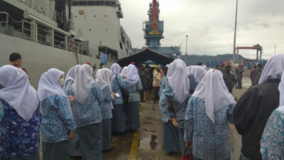ANTRI - Puluhan pelajar di Kota Padang antri menjelang menaiki kapal perang KRI Bontang 907 untuk mengikuti vaksinasi sekaligus mengenal lebih dekat armada penjaga laut NKRI itu. (bambang)