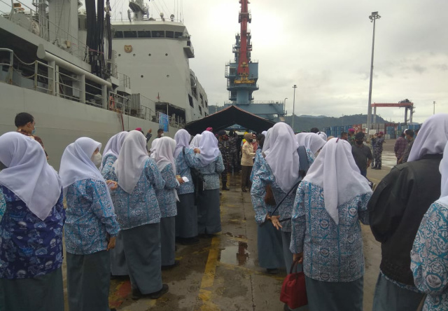 ANTRI - Puluhan pelajar di Kota Padang antri menjelang menaiki kapal perang KRI Bontang 907 untuk mengikuti vaksinasi sekaligus mengenal lebih dekat armada penjaga laut NKRI itu. (bambang)