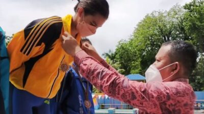Kadispora Kota Padang Mursalim mengalungkan medali kepada pemenang cabang renang dalam Porkota Padang 2021.
