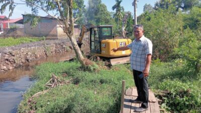 Ketua LPM Dadok Tunggul Hitam menunjuk saluran air yang dikeruk