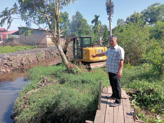 Ketua LPM Dadok Tunggul Hitam menunjuk saluran air yang dikeruk