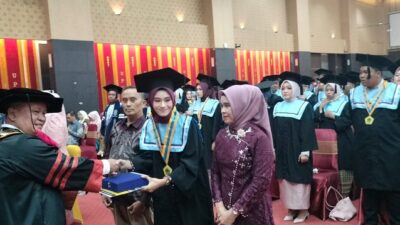 Rektor Universitas PGRI Prof. Dr. H. Ansofino. M. Si, menyerahkan ijzah kepada Wisudawati terbaik