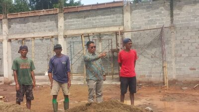 Kades Batu Tanjung Marwan,S.Sos tengah memberikan komando pada tukang Peroyek KDMP Kamis (18/6) agar mempercepat pekerjaan. (subandi)